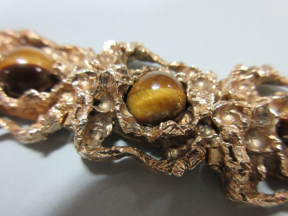 A 9ct gold and tiger's eye bracelet, the nine pierced, deeply-modelled, heavy cast links each set - Image 2 of 5