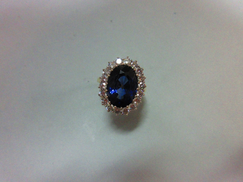 A large sapphire and diamond cluster ring, the oval cut deep blue sapphire, estimated weight 9.