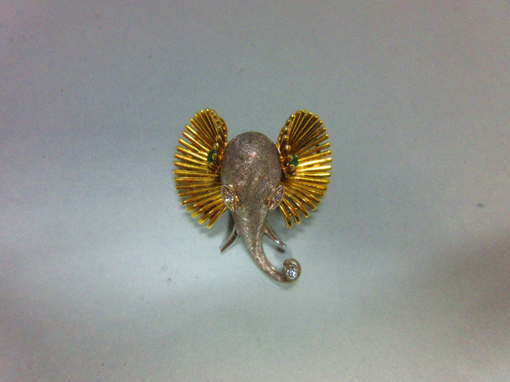 A bi-coloured precious metal, diamond and emerald set elephant head brooch, designed as a white