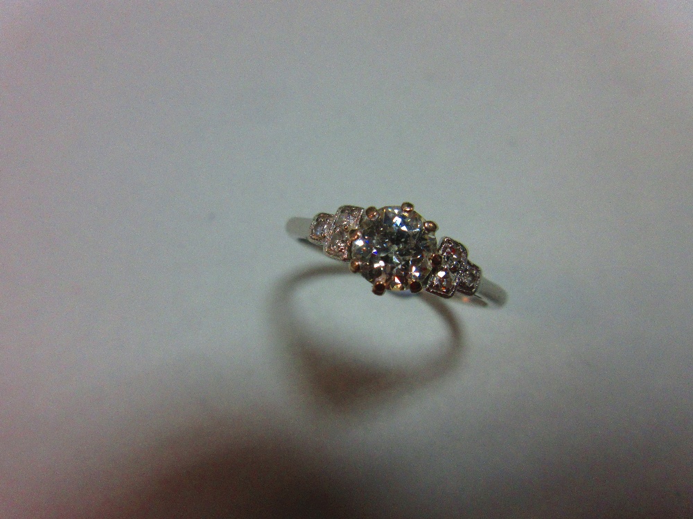 A diamond ring, the old round brilliant cut diamond claw set between stepped square millegrain edged