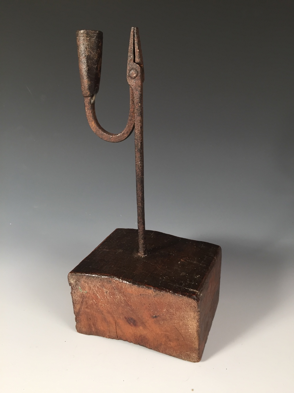 An 18th century iron rushlight holder with later wooden base, the square stem topped by a squared - Image 2 of 4