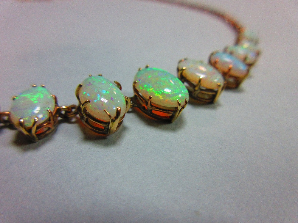 A graduated opal necklace, set to the front with an articulated line of eleven oval cabochon opals - Image 5 of 6