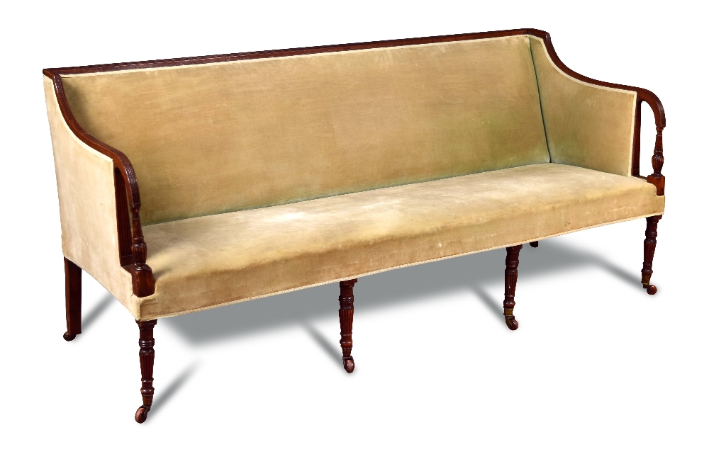 An 18th century mahogany square back sofa, with reeded show wood and open arms, on reeded legs and