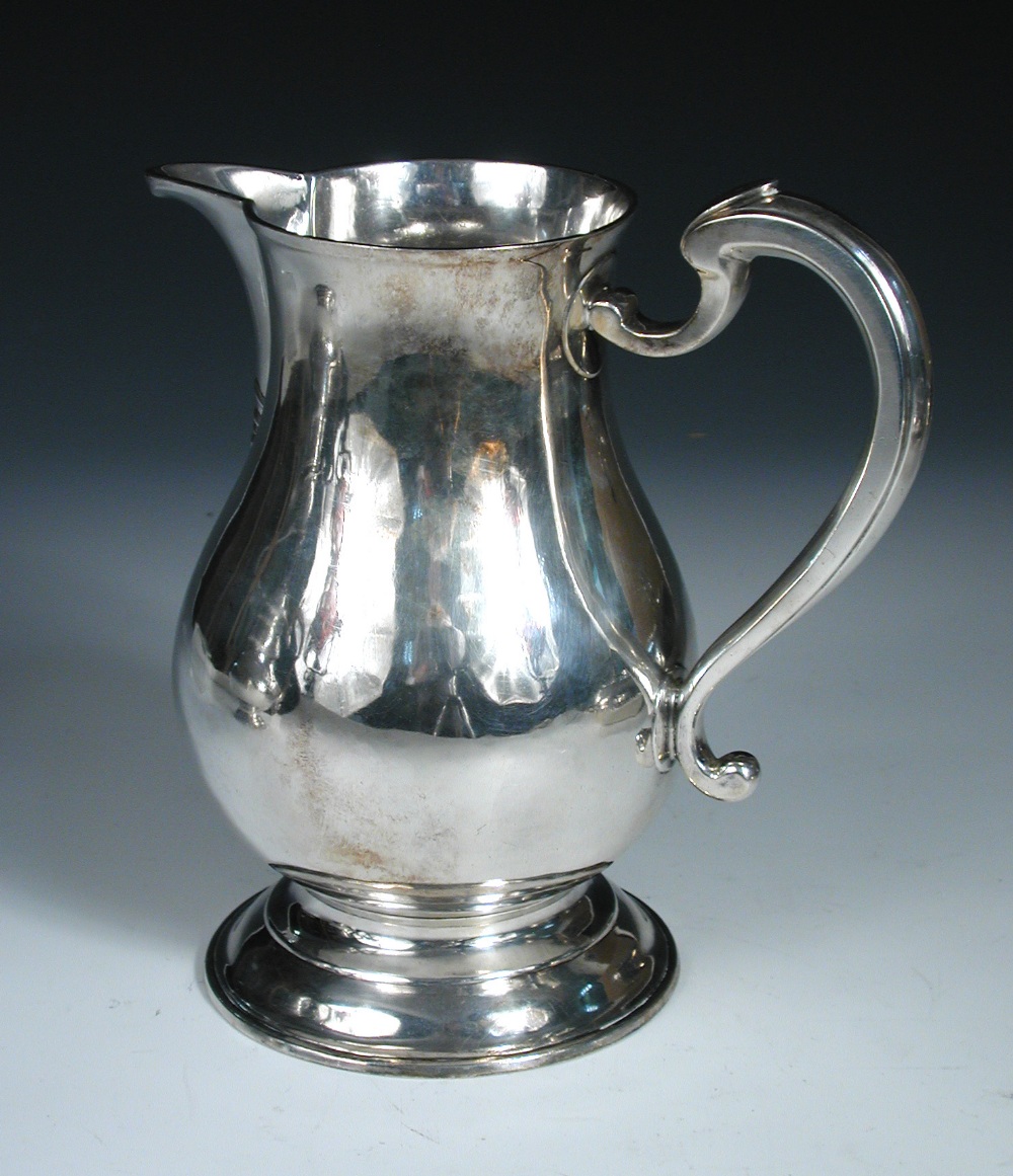 A George II silver ale jug, by Jonathan Fossy, London 1742, of plain baluster form over a