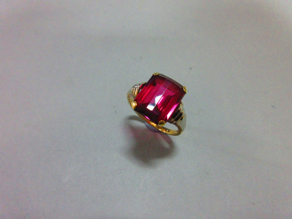 An Austrian single stone synthetic red spinel ring, the fancy cut rectangular pinky-red spinel, claw