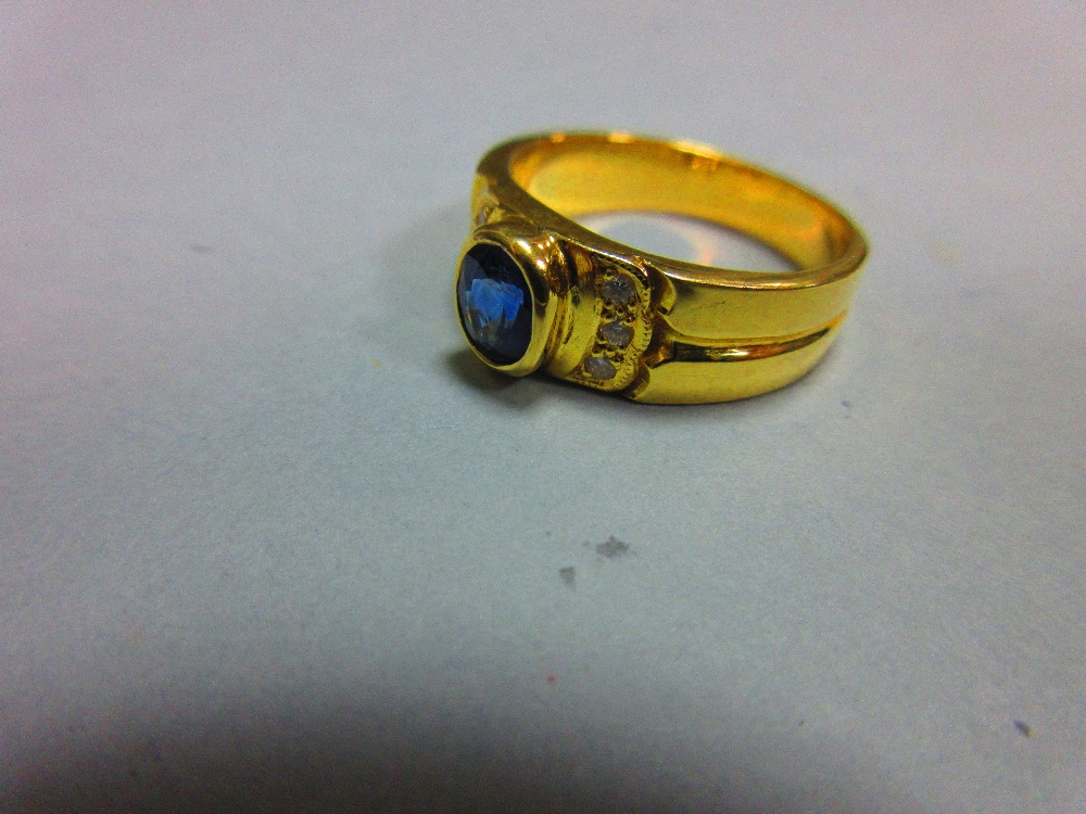 A sapphire and diamond ring, the oval cut intense blue sapphire in a raised collet between lines - Image 2 of 4