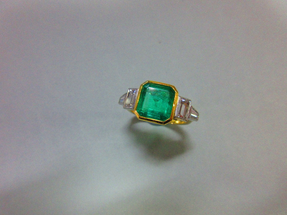 An 18ct gold emerald and diamond ring by Theo Fennell, the near-square emerald cut emerald,