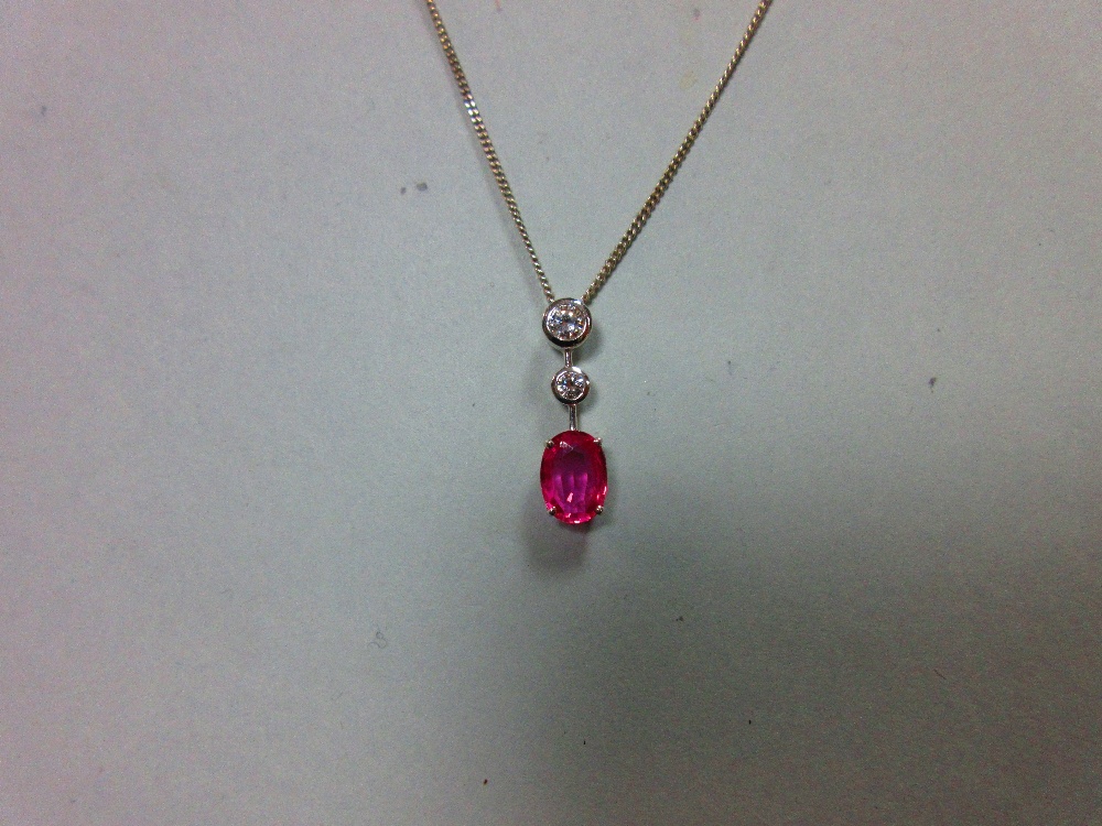 A pink sapphire and diamond pendant set in 18ct white gold, designed as a line of three stones