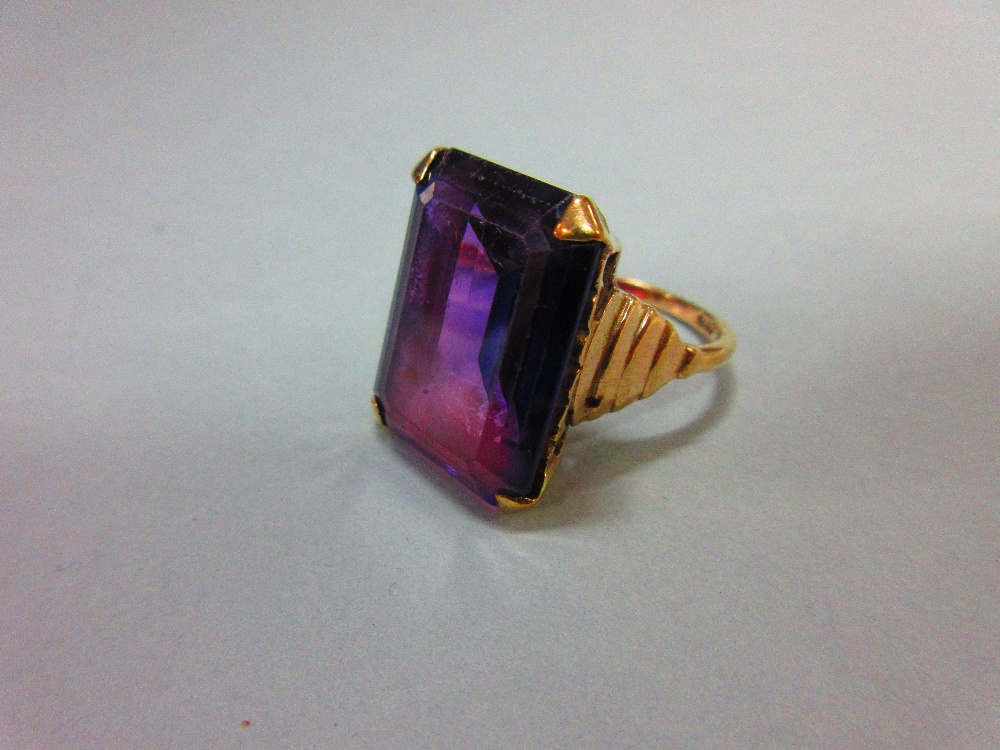 A synthetic colour change sapphire ring, the large step cut stone appearing blue in daylight and - Image 2 of 4