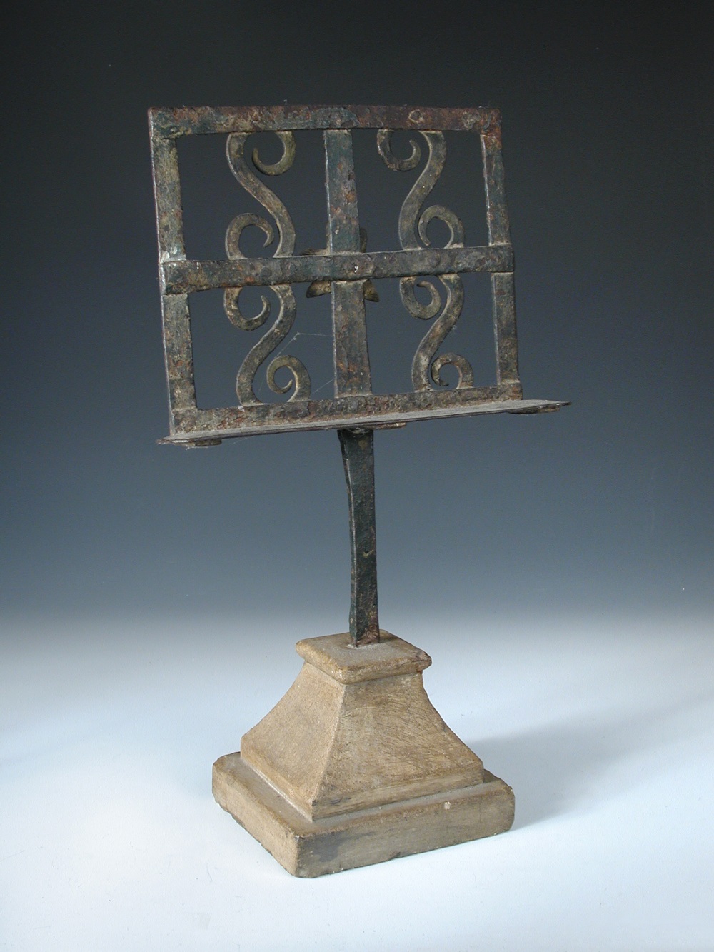 A 19th century wrought iron table lectern, the rectangular stand with applied s-scrolls and