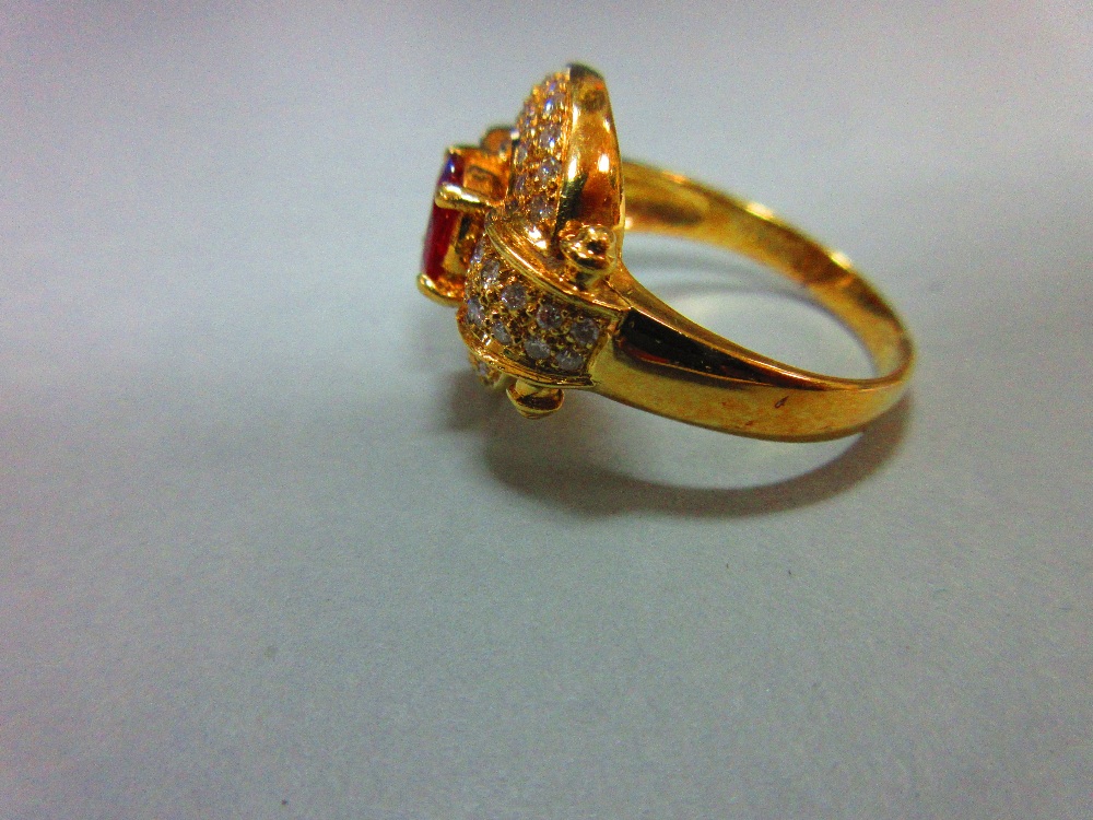 A red hardstone and diamond cluster ring, the oval cut red stone, believed to be a ruby, but not - Image 3 of 5