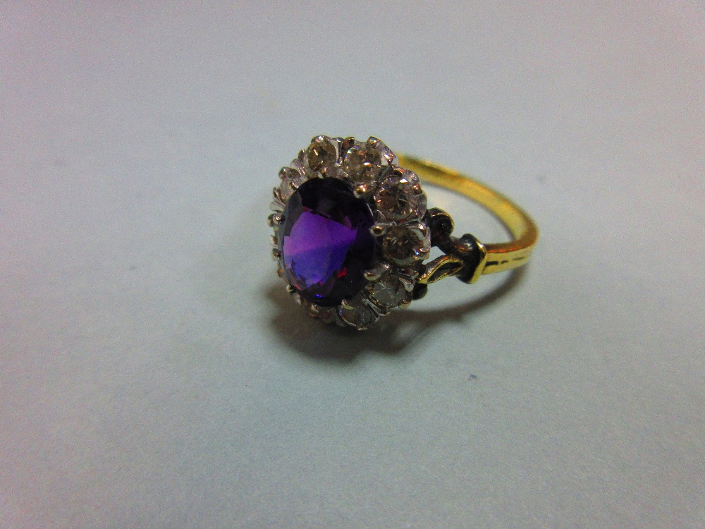 An amethyst and diamond cluster ring, the oval mixed cut rich purple amethyst claw set in a border - Image 2 of 8