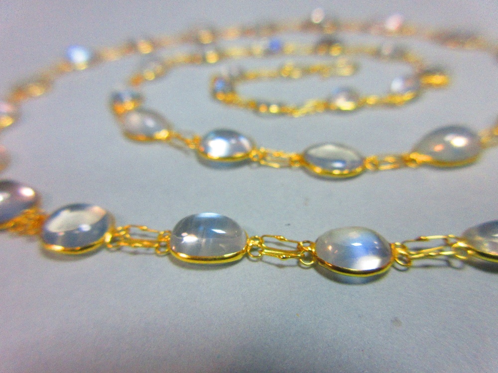 A moonstone necklace, designed as a chain of graduated spectacle set cabochon moonstones joined by - Image 2 of 4