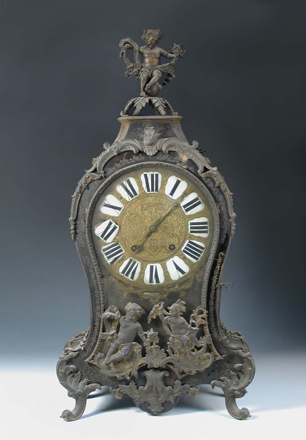 A French 18th century Boullework mantel clock, the waisted case with gilt metal mounts, enamelled