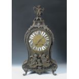 A French 18th century Boullework mantel clock, the waisted case with gilt metal mounts, enamelled