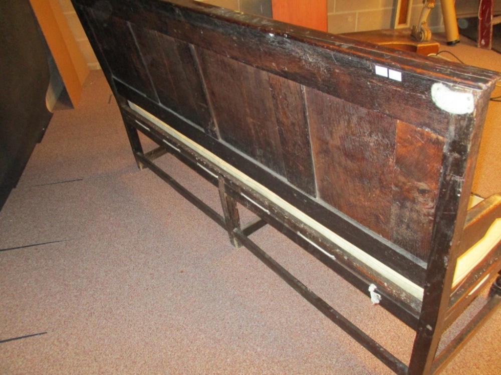 An early 18th century oak panelled settle, with open arms, strung seat and loose cushion, on - Image 2 of 4