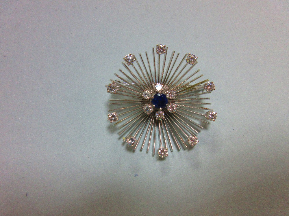 A mid 20th century diamond and sapphire flower brooch, formed by a central round cut sapphire in a