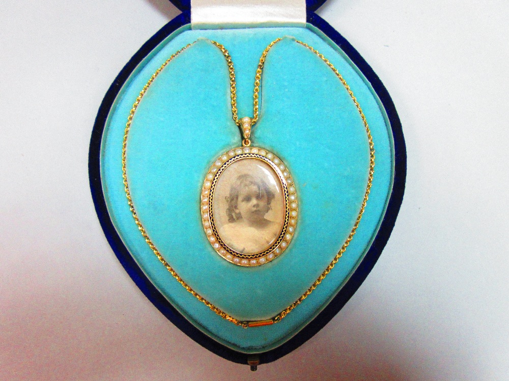 A pearl and enamel miniature frame pendant necklace in fitted case, the oval double-sided frame