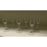 A set of six 18th century wines, each with cylindrical bowls rounding into the facetted stems on