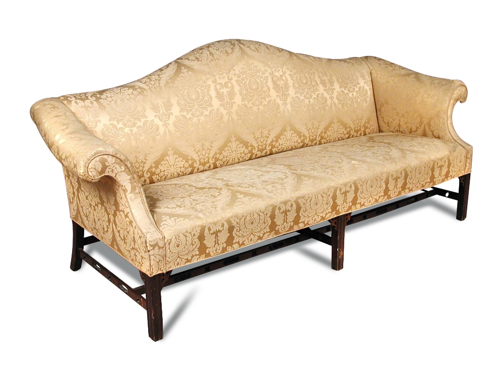 An 18th century style mahogany sofa, with camel back and outscrolling arms, on pierced mahogany