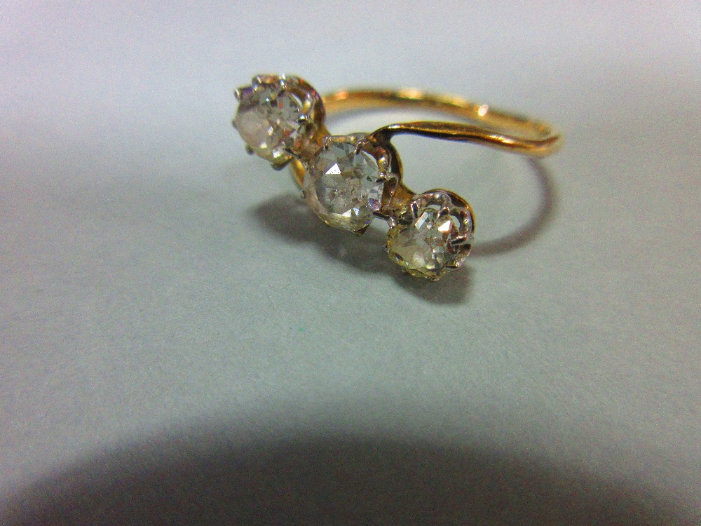 A three stone diamond ring, the three old cushion cut diamonds claw set in a diagonal line to a fine - Image 2 of 6