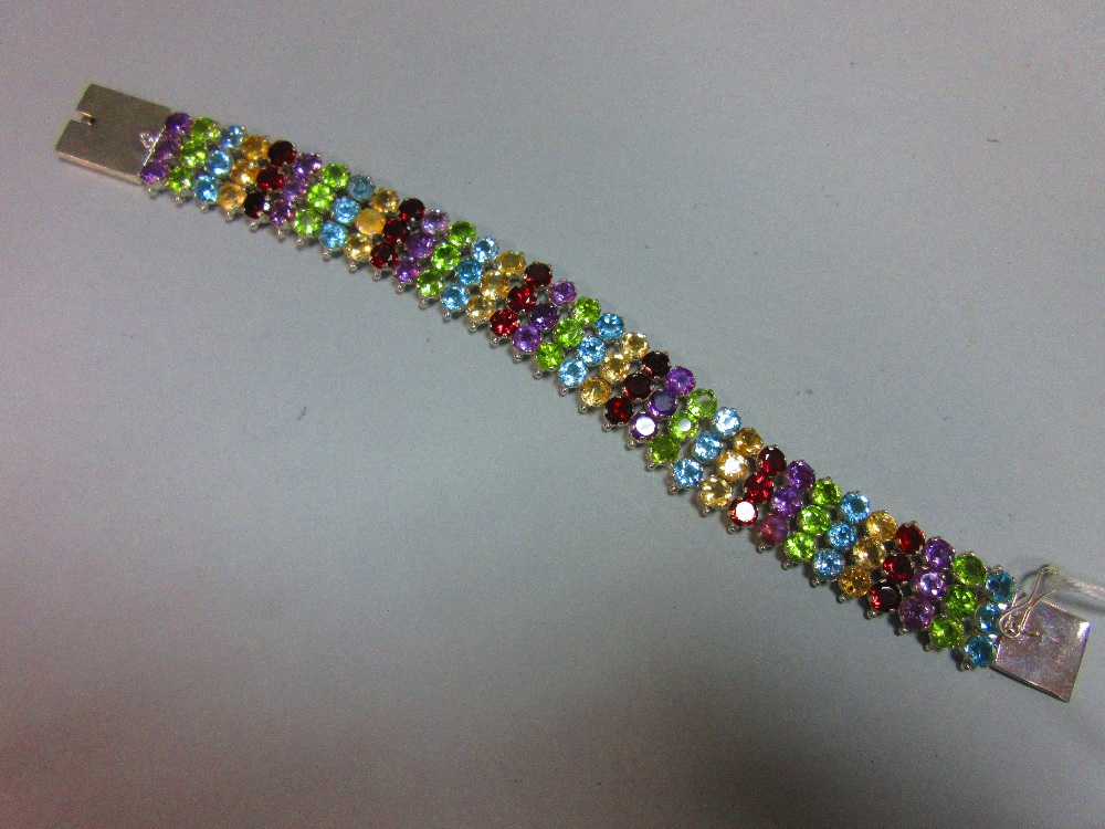 A multi gemset bracelet, composed of vertical lines of three round cut stones, alternating