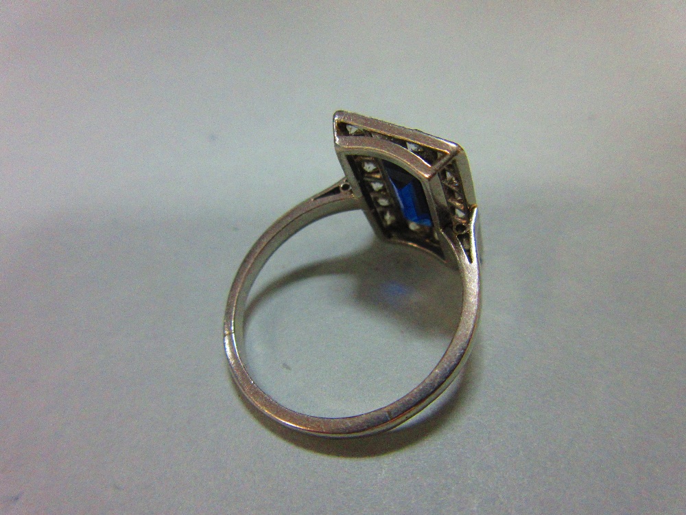 A mid 20th century sapphire and diamond ring, the rectangular step cut royal blue sapphire in a - Image 3 of 6