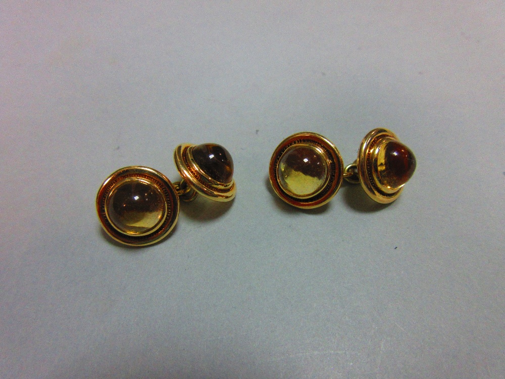 A pair of citrine set double ended cufflinks, each end with a round cabochon pale gold citrine