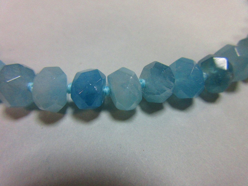 An aquamarine faceted bead necklace, the uniform 9mm faceted beads, individually knotted to a - Image 2 of 5