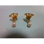 A pair of pearl and diamond earstuds, each with a pierced triangular fan motif set with three