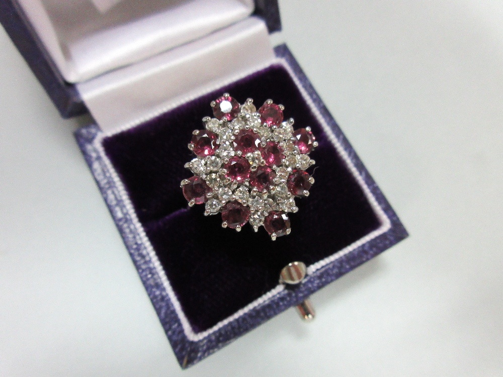 A ruby and diamond cluster ring in 18ct white gold, designed as a densely set diaper with a