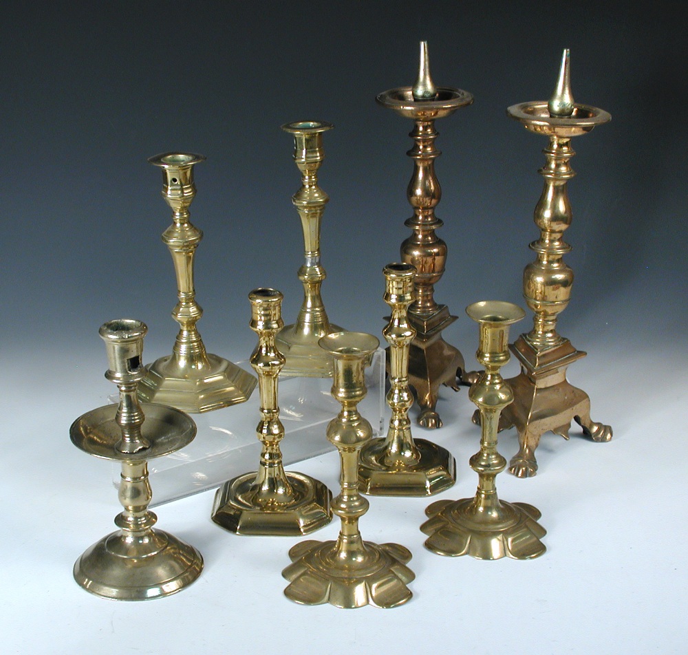 Four pairs and a single brass candlestick, the latter the earliest with dished drip pan, baluster