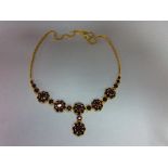 A Bohemian garnet cluster necklace, composed of five flowerhead clusters of round cut garnets,