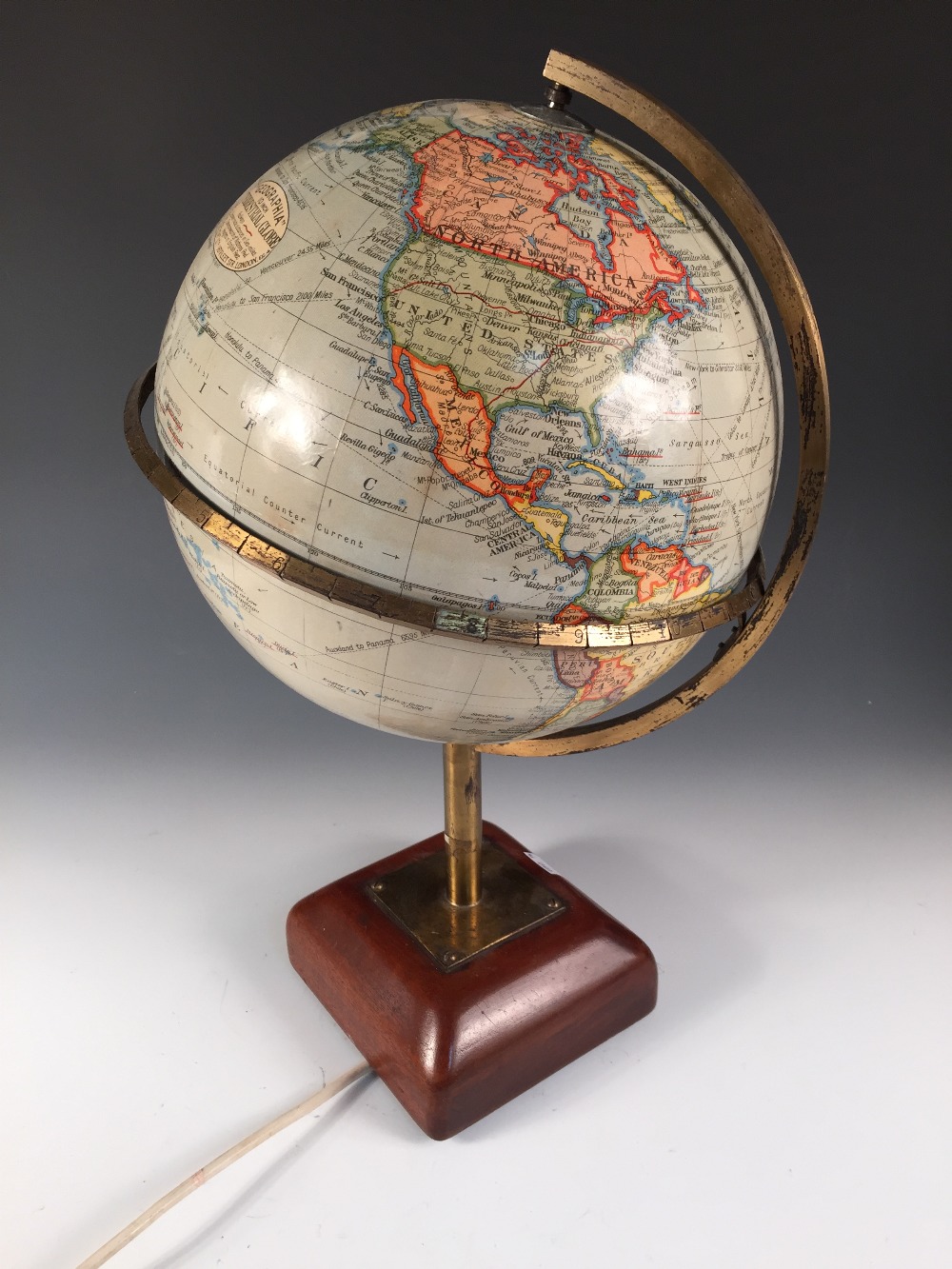 A Geographia 10 inch electric terrestrial globe, on a lacquered brass support and moulded wooden