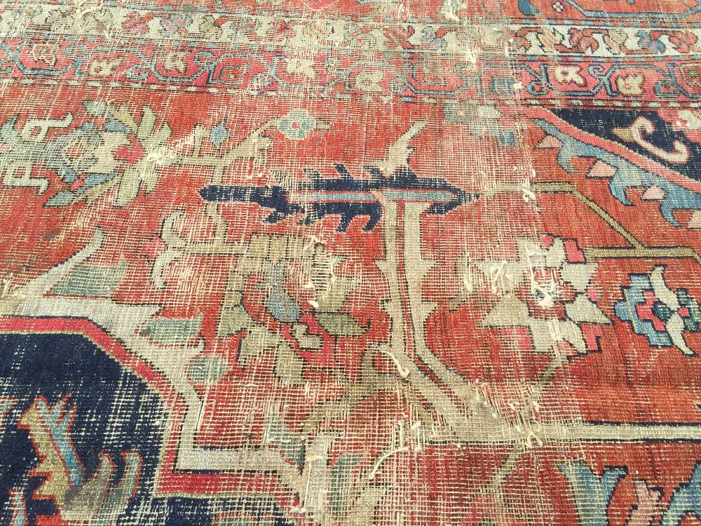 A large Heriz wool carpet, 734 x 485cm (286 x 189in) Worn and holed with end border losses, but well - Image 3 of 10