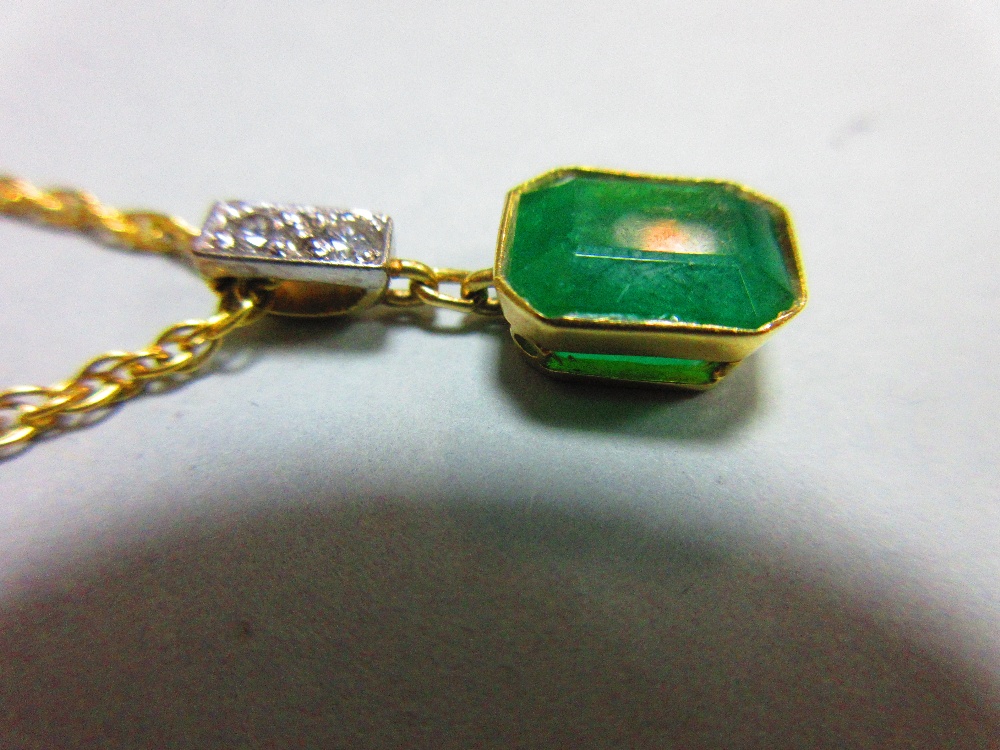 An emerald and diamond pendant set in 18ct gold, with chain, the emerald cut emerald collet set - Image 4 of 5