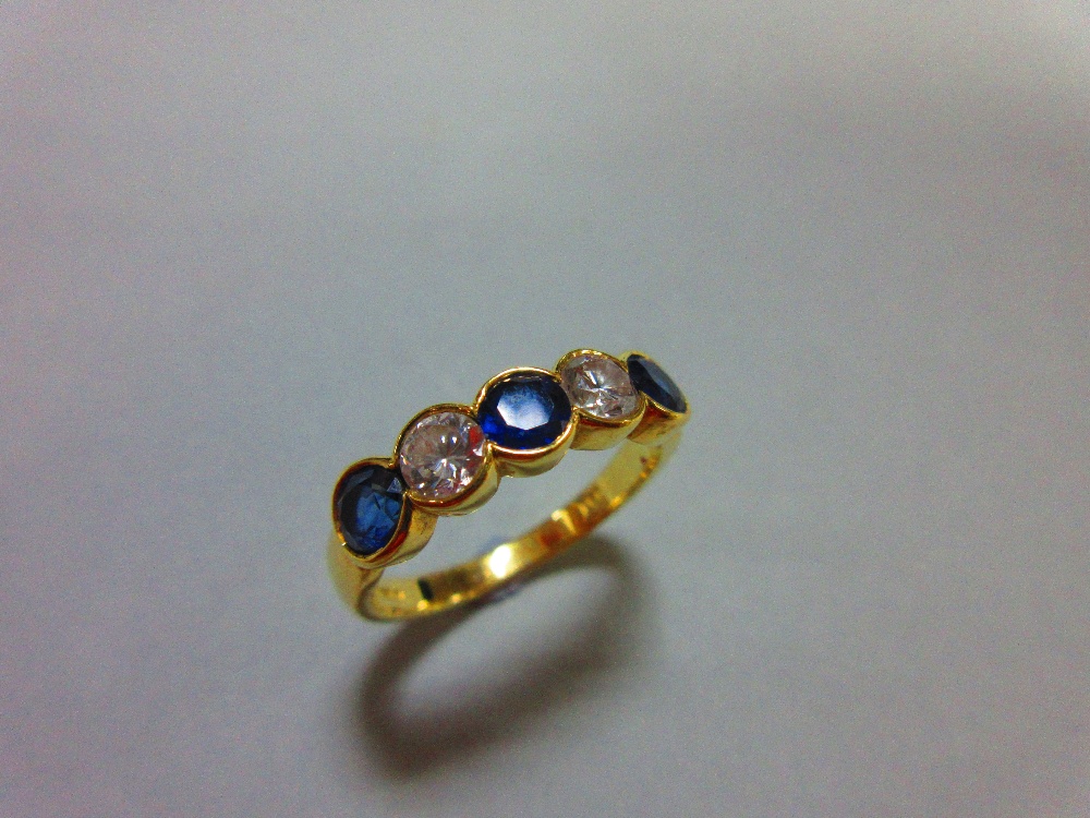 An 18ct gold, sapphire and diamond five stone ring, with two round brilliant cut diamonds spacing