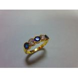 An 18ct gold, sapphire and diamond five stone ring, with two round brilliant cut diamonds spacing