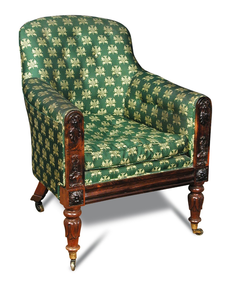 A late Regency rosewood library armchair, button upholstered in a green patterned fabric, the show