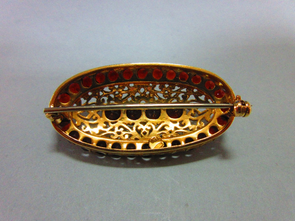 An Italian 18ct gold and garnet brooch, of elongated oval outline delineated by round cut deep red - Image 3 of 4