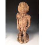 A Mediaeval style carved wood figure, possibly of Adam, the bearded figure naked with his left