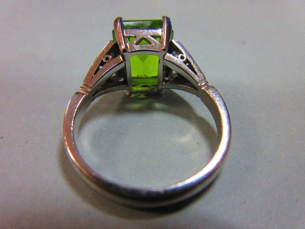 A 1930s style peridot and diamond ring, the emerald cut peridot measuring 10.6 x 8.7mm, four claw - Image 4 of 5