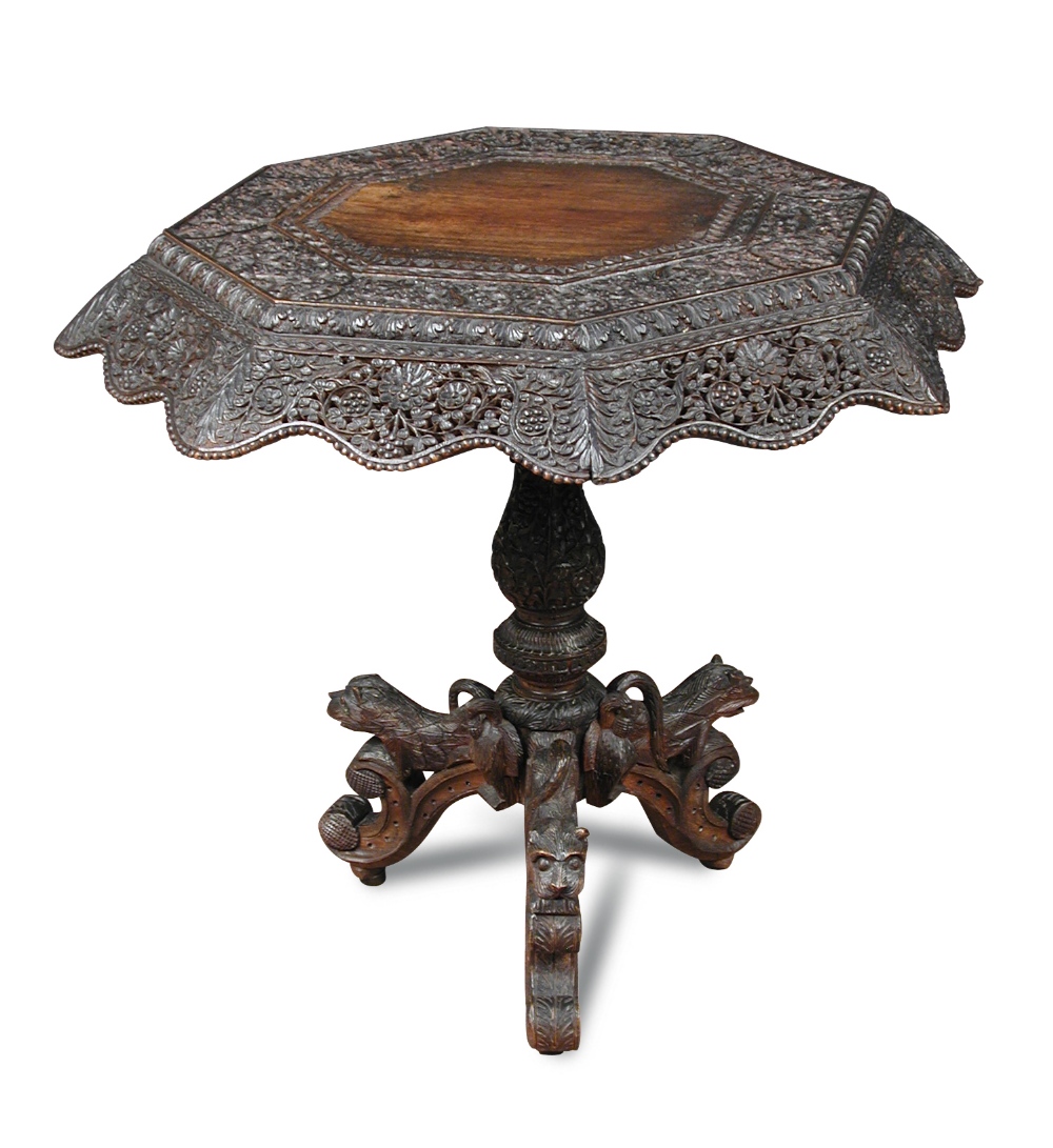 An Indian carved blackwood pedestal table, octagonal top decorated with birds and animals on a