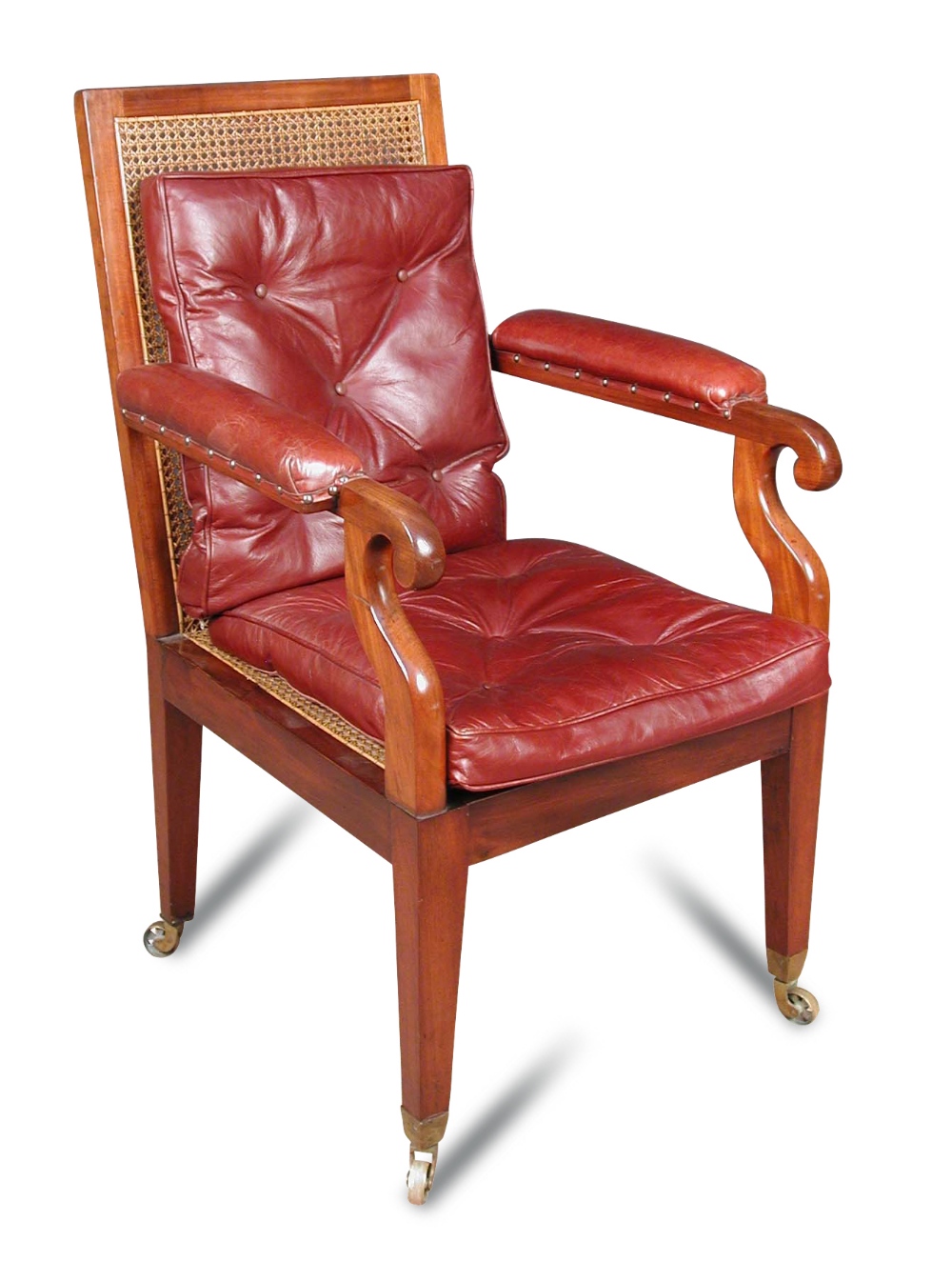 A Regency mahogany library bergere, the arms upholstered in red leather, cane seat with loose