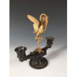 A 19th century French gilt metal and bronze candelabra, with a stork and serpent standing on a