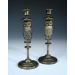 A pair of late 19th century brass candlesticks, the columnular stems set with a figure of a cold