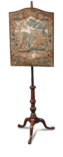 A George III mahogany pole screen, with arched needlepoint panel, on a turned moulded column and a