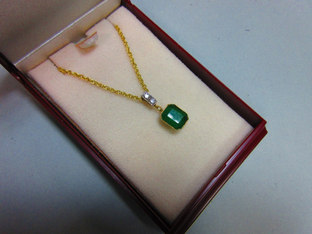 An emerald and diamond pendant set in 18ct gold, with chain, the emerald cut emerald collet set