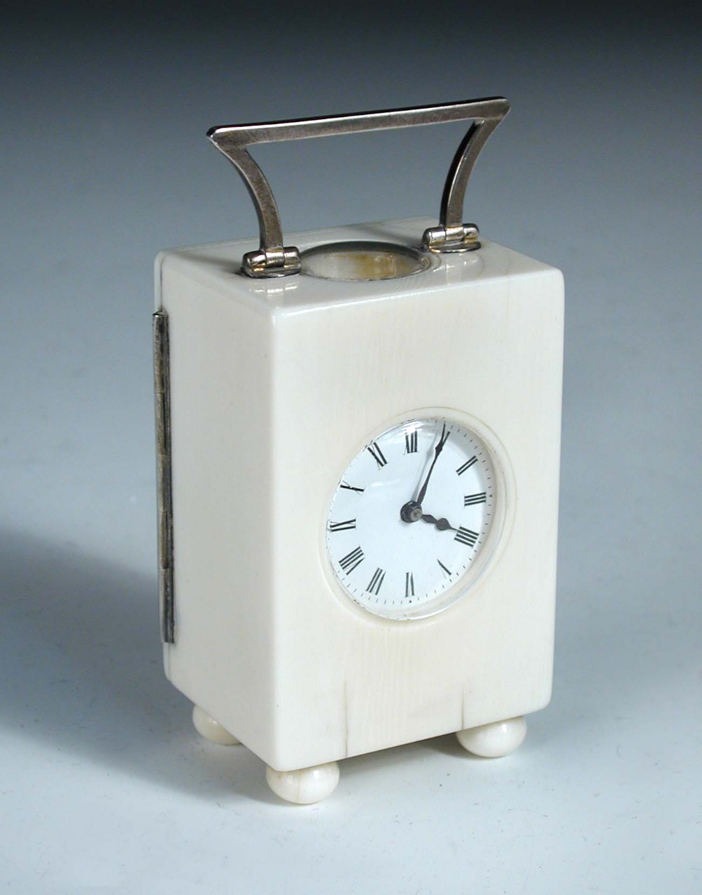 A French ivory cased miniature carriage timepiece, with shaped silver handle and hinge to the rear