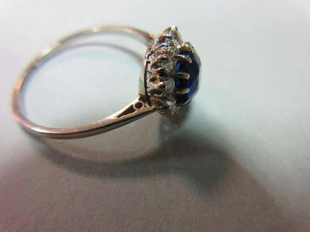 A sapphire and diamond cluster ring, the round cut sapphire in a border of old variously round cut - Image 5 of 5